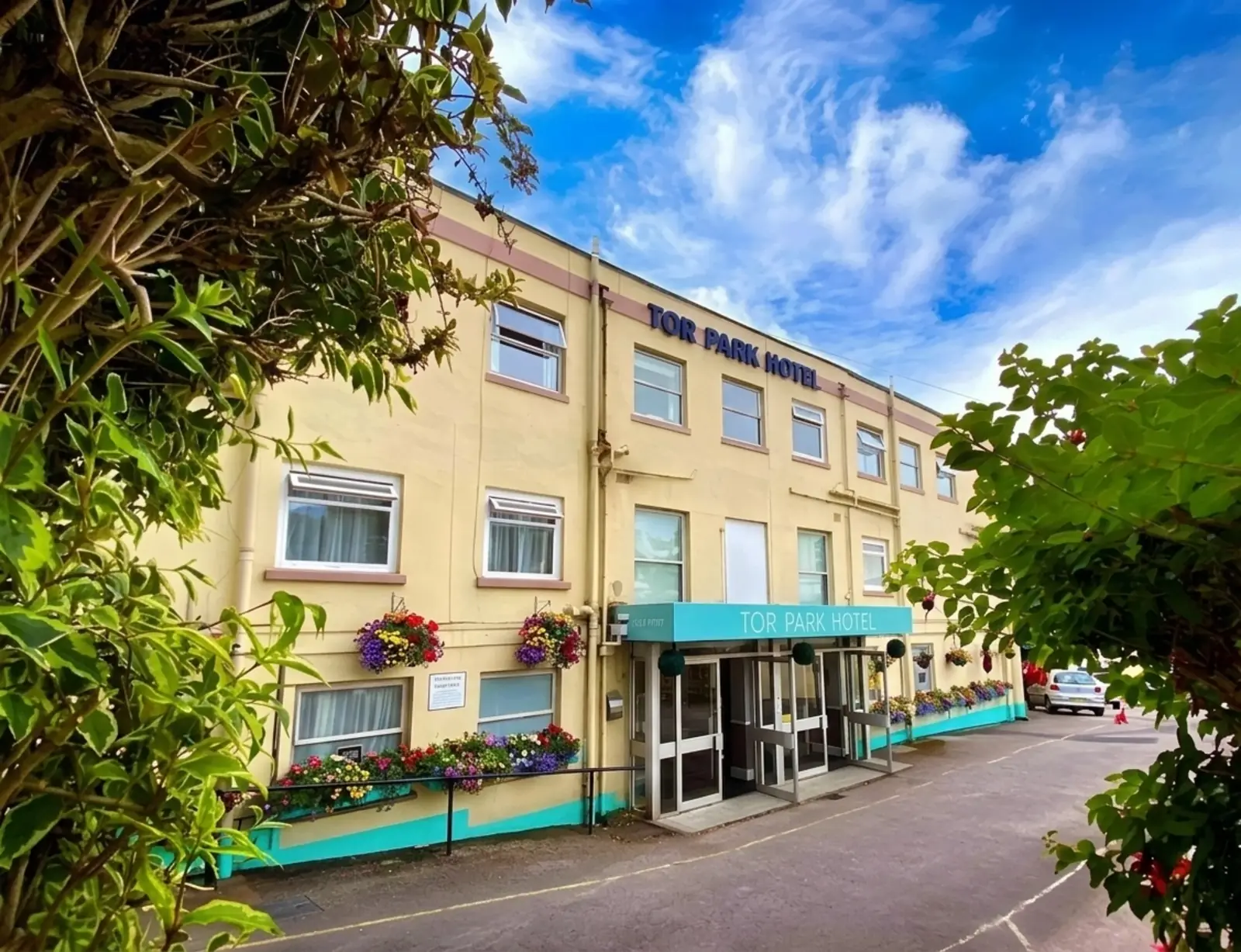 Torpark Hotel exterior in Torquay with turquoise awning and flower-filled window boxes
